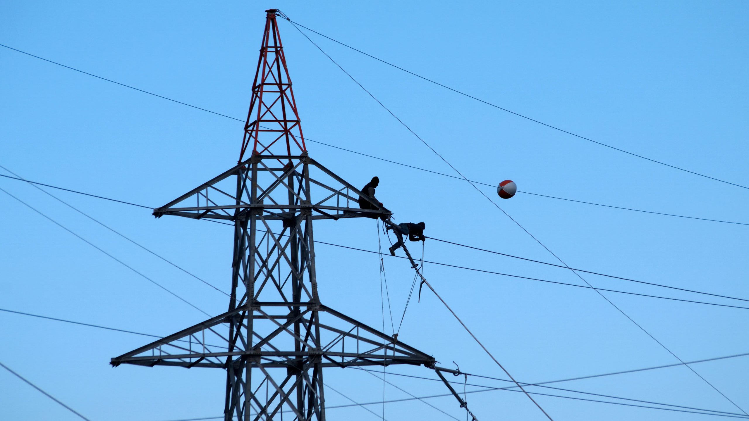People working in a high risk environment on top of a power pylon